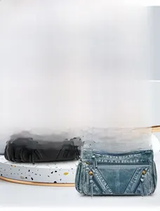 Detail of multi-layer zipper pockets on soft black leather and blue denim crossbody bags