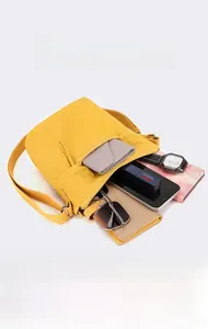 Detailed internal view of yellow nylon crossbody bag showing mass storage capacity
