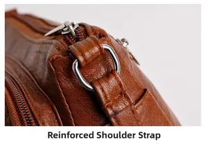 Detailed shot of reinforced shoulder strap attachment on brown litchi leather bag
