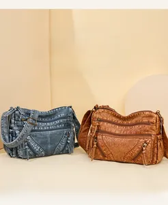 Macro detail of vintage washed leather crossbody bags with multi-zipper and tassel design