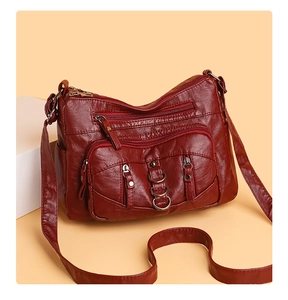 Detailed view of the multi-pocket burgundy crossbody bag with metal ring accents