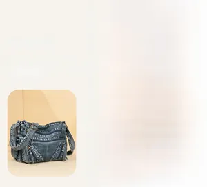 Close-up of vintage blue denim crossbody bag featuring multiple zippers and tassel details