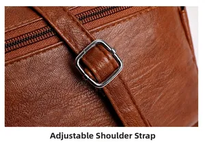 Detail of adjustable shoulder strap with silver buckle on brown pebbled leather bag