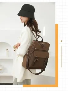 Zaino marrone alla moda con dettagli in pelle indossato da una modella in studio