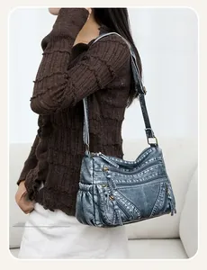 Detail of vintage blue crossbody bag with multiple zip pockets and adjustable strap