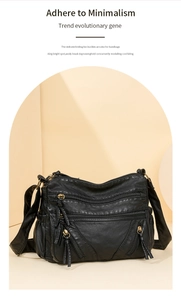 Close-up of black washed leather crossbody bag with multiple zipper compartments and adjustable strap