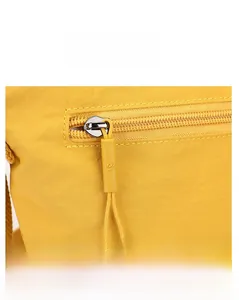 Close-up of bright yellow nylon bucket bag showing high-quality zipper and metal logo puller