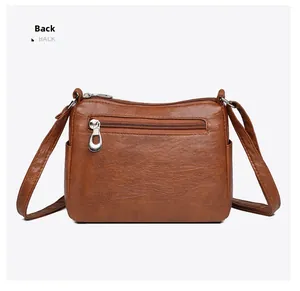 Back view of brown crossbody bag showing smooth texture and horizontal zip pocket