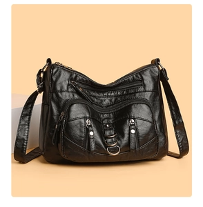 Detail of black multi-zipper crossbody bag with textured PU leather and metal ring accents