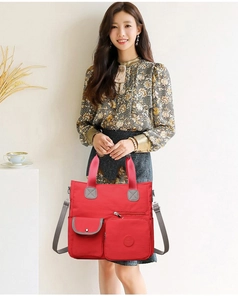 Detailansicht der roten Nylon-Tragetasche mit Multi-Pocket-Design und grauem Gurt