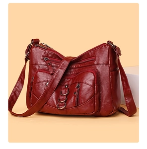 Detail view of burgundy multi-pocket crossbody bag with vintage washed leather texture