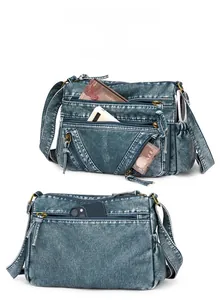 Macro view of blue vintage washed crossbody bag showing multiple zip pockets storage