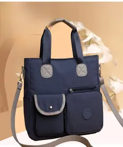 Detail der dunkelblauen Nylon-Einkaufstasche mit grauen Riemen und praktischen Taschen