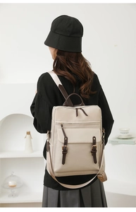Vista dettagliata dello zaino in nylon beige con spallacci in pelle PU marrone scuro