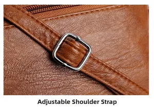 Detail of adjustable shoulder strap with silver buckle on brown pebbled leather bag