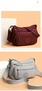 Detail view of water-resistant nylon crossbody bags in deep red and light grey colors