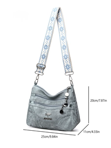 Detail showing blue denim texture tote bag with dimensions and embroidered strap