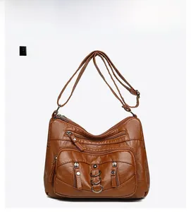 Front detail of vintage brown crossbody bag with multi-zipper pockets and textured finish
