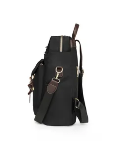 Vista laterale dello zaino in nylon nero con rifiniture in pelle marrone e anelli dorati
