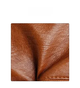 Close-up of caramel leather texture and precise stitching on the large shoulder bag