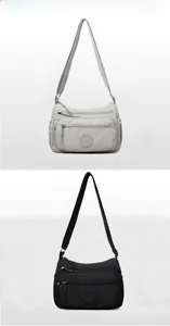 Close-up of waterproof nylon crossbody bags showing multiple zippers and adjustable straps