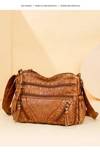 Close-up of brown vintage washed leather crossbody bag with multiple zipper pockets
