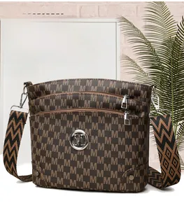 Detailed view of brown monogram crossbody bag with triple zippers and woven strap