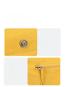 Detail of yellow nylon bucket bag showing silver logo and smooth zipper closure