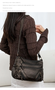 Macro shot of vintage washed leather crossbody bag with multiple functional zippers