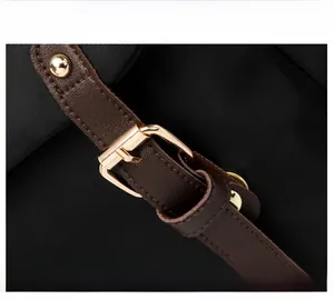 Dettaglio dello zaino in nylon nero con cinturini in pelle marrone e fibbie dorate