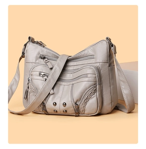 Detail of grey soft PU leather multi-layer crossbody bag with woven lines and metal rivets
