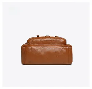 Detailed bottom view of brown leather crossbody bag with double stitching and pebble texture