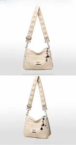 Close-up of beige faux leather tote with three front zippers and ethnic jacquard strap