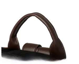 Dettaglio del manico in pelle marrone scuro e tessuto di nylon nero dello zaino
