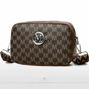 Vue latérale du sac caméra marron avec motif M et large bandoulière tissée