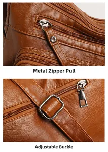 Detail of smooth metal zipper pull and adjustable buckle on brown lychee leather bag