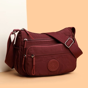 Waterproof dark red nylon crossbody bag with multiple zippers and wide strap