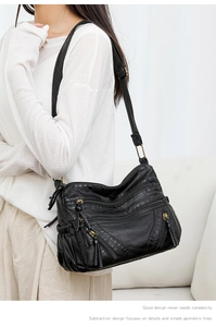 Detail view of black PU leather crossbody bag with multiple front zipper pockets for women