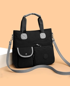 Nahaufnahme der schwarzen Nylontasche mit Multi-Pocket-Design und grauen Trägern
