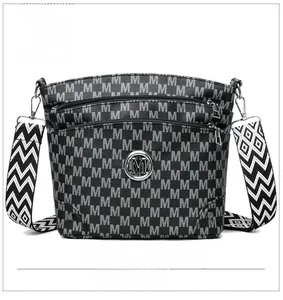 Close-up of black crossbody bag with M-pattern print and textured herringbone strap