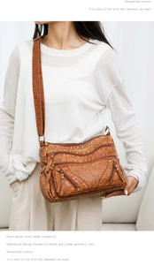 Detail view of vintage brown leather crossbody bag with multiple functional zip pockets