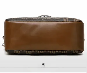Détail du fond plat en cuir marron et du tissu imprimé M vintage du sac pour appareil photo