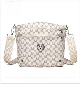Detailed front view of ivory crossbody bag featuring classic M logo and wide geometric strap