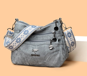 Close-up of grey texture shoulder bag featuring kangaroo logo and woven jacquard strap