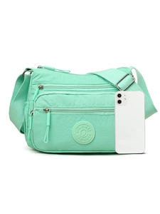 Size comparison of a mint green nylon crossbody bag next to a smartphone