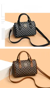 Close-up of vintage M-letter print on leather Boston bags with metallic logo details