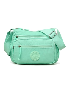 Detailed close-up of mint green nylon crossbody bag with multi-layer zipper compartments