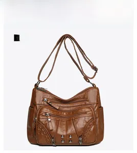 Front view of vintage brown multi-pocket crossbody bag with woven stitching and rivets
