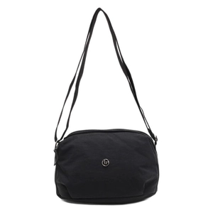 Minimalist black canvas dumpling crossbody bag with round metal logo on white background