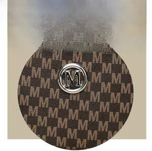 Macro shot of silver M-logo hardware and brown monogram pattern on vintage shoulder bag